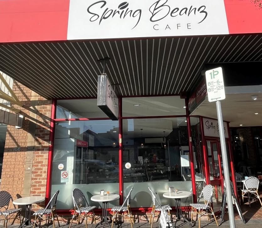 Spring Beanz Cafe shopfront on Macquarie Road, Springwood — red awning and bentwood chairs on the pavement